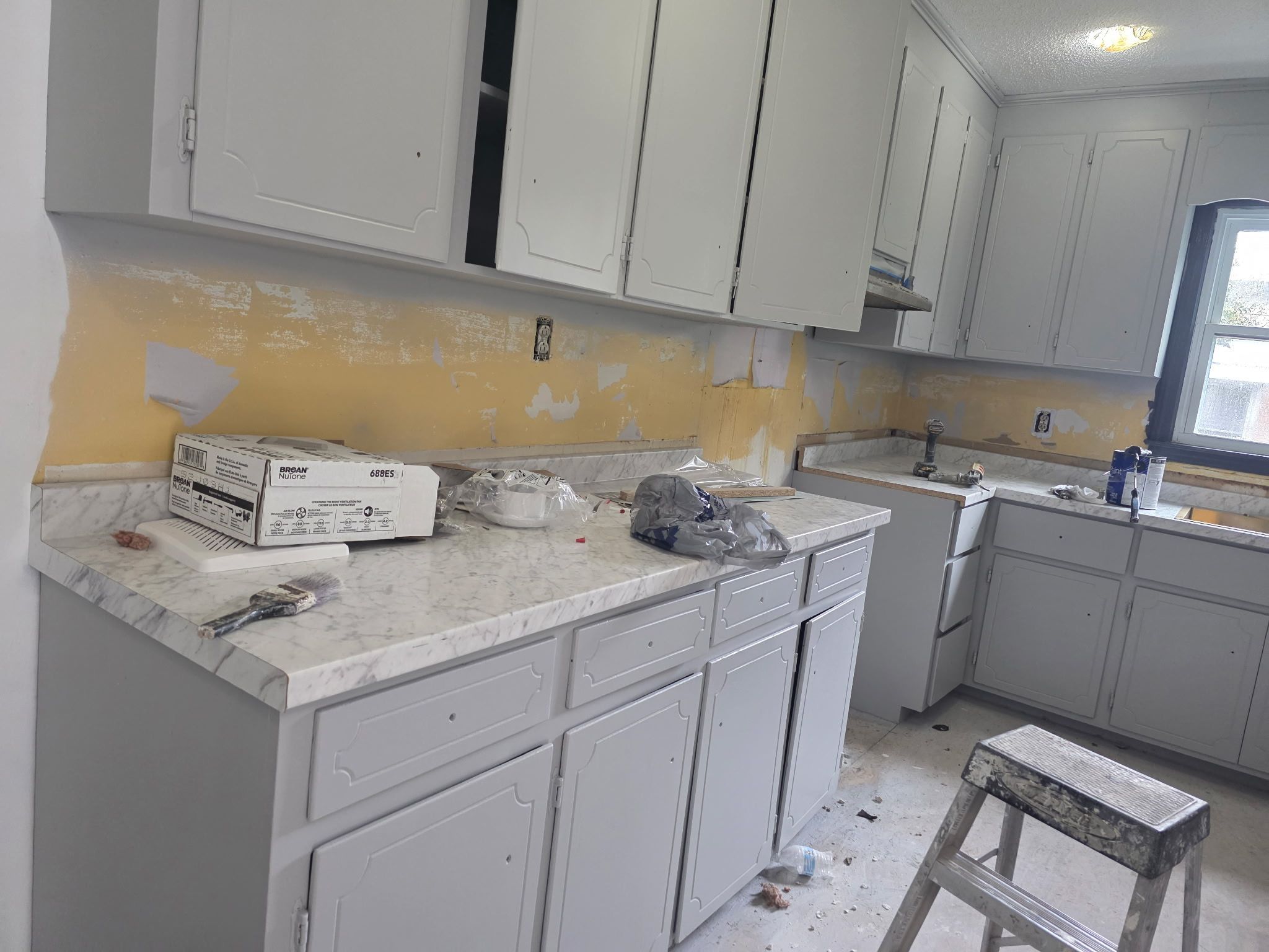 Cabinet Painting — kitchen cabinets freshly painted light gray with marble countertops in Apex, NC