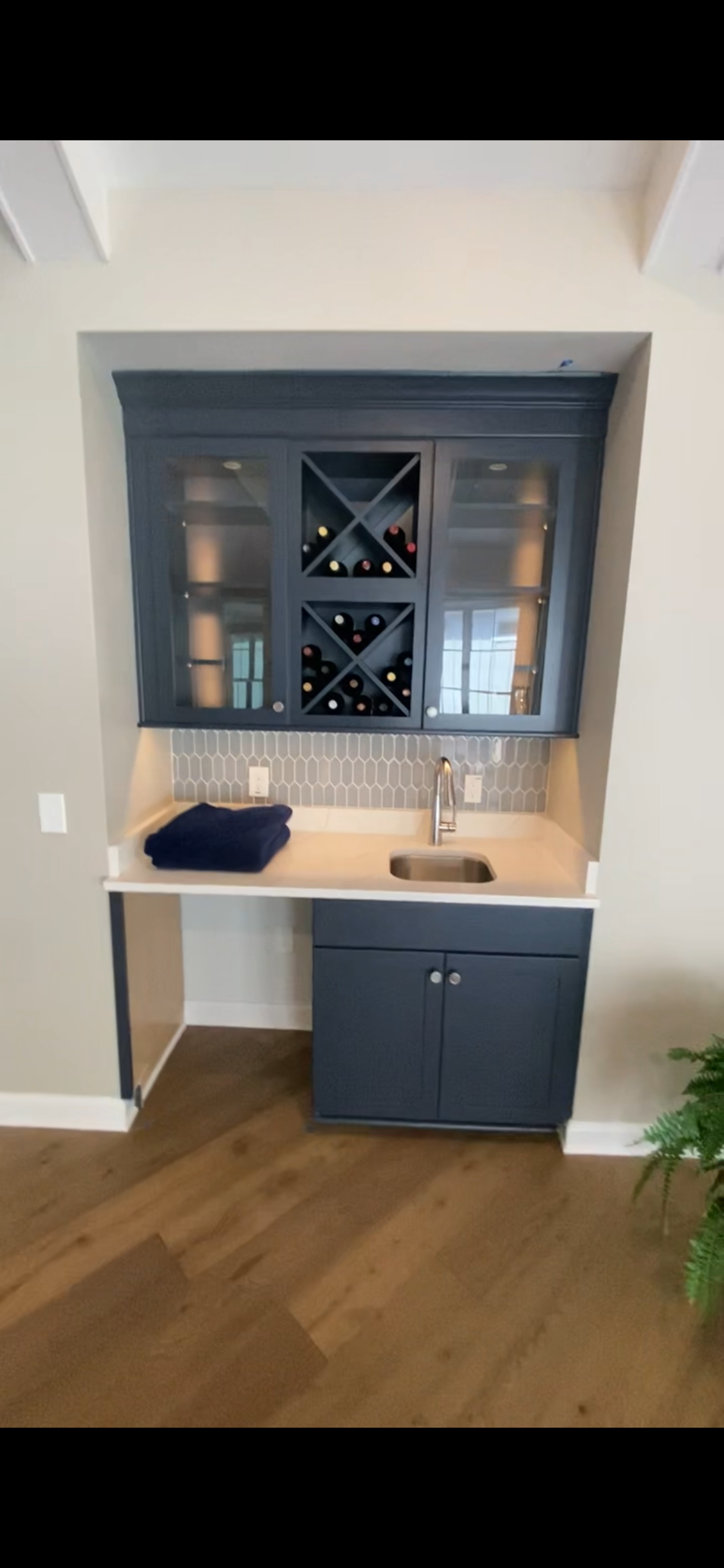 Cabinet Painting — built-in wet bar with navy-blue cabinets, wine rack, and glass-front doors in Cary, NC