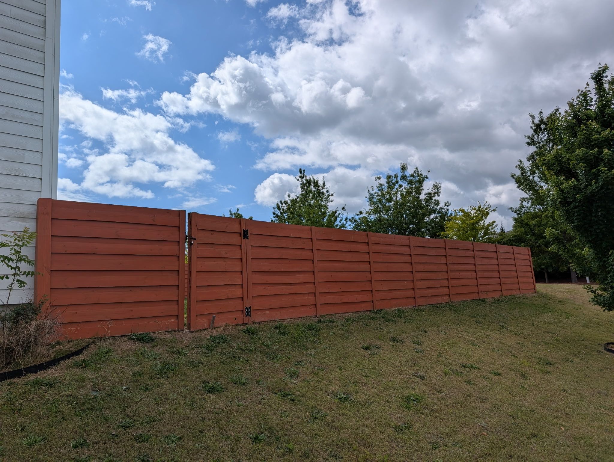 Fence Staining — horizontal-board wood fence in deep reddish-brown stain in Cary, NC