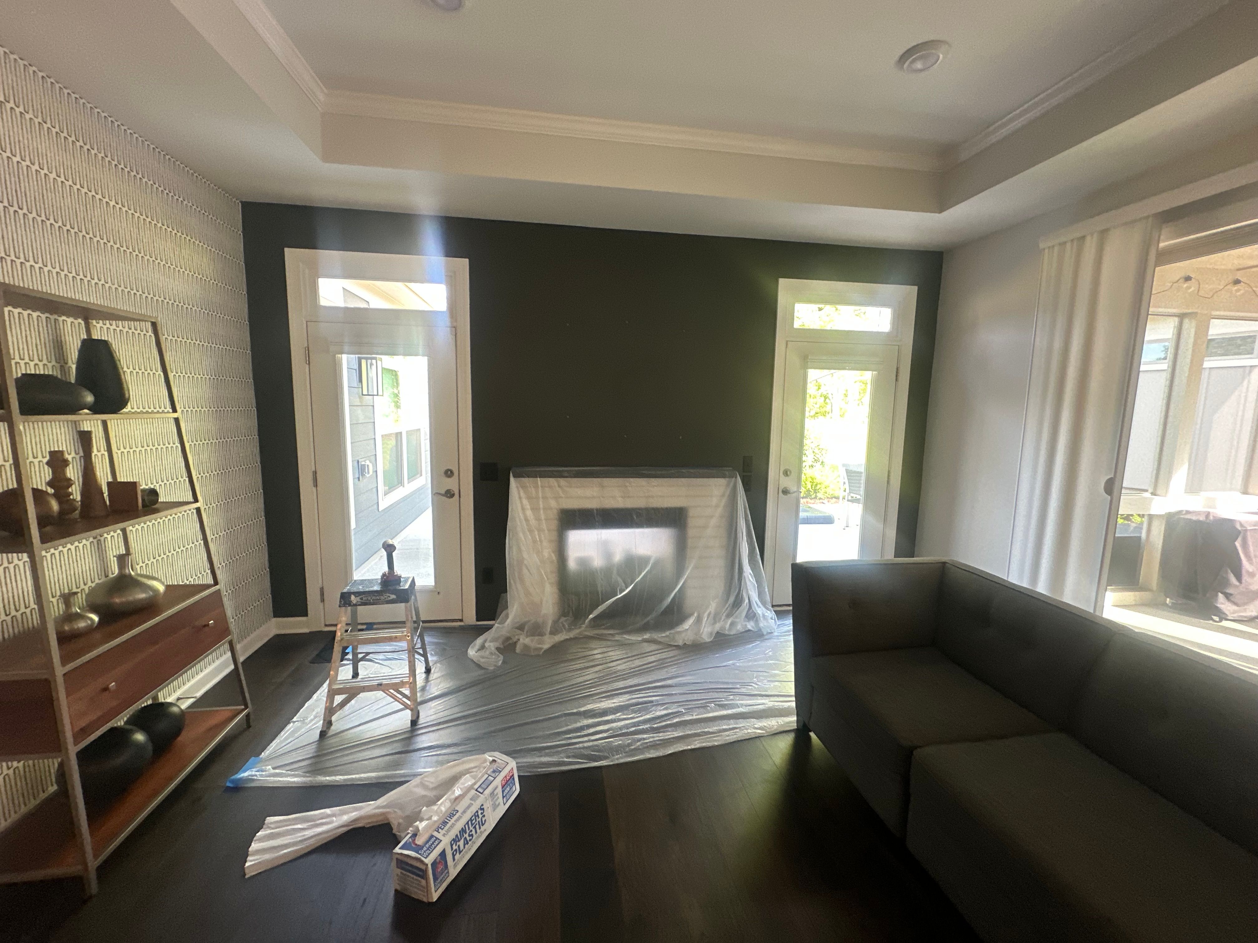 Interior Painting — living room with deep olive-green accent wall and patterned wallpaper in Cary, NC