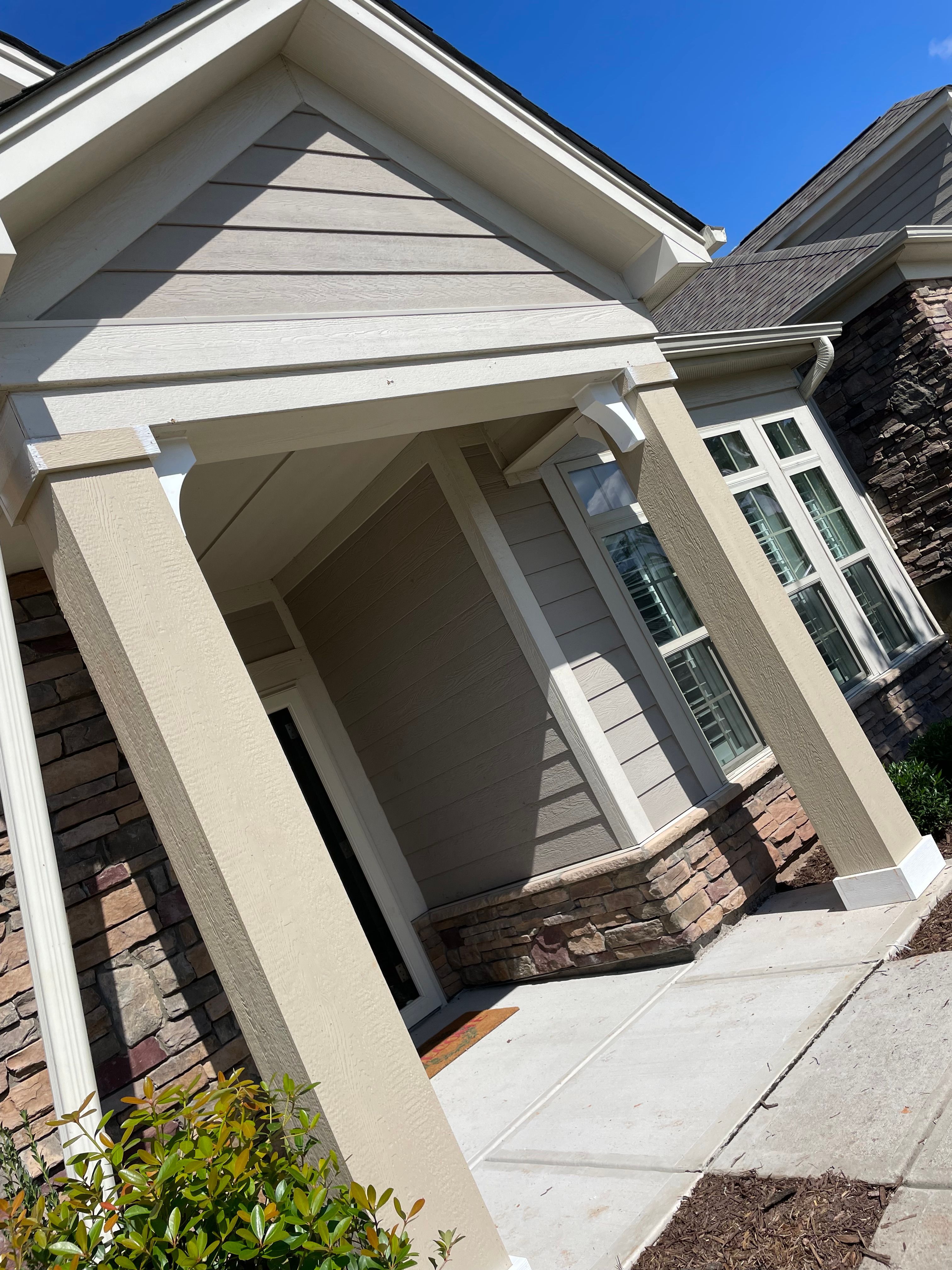 Exterior Painting — multi-story home corner with cream smooth siding, white trim, and stone column in Chapel Hill, NC